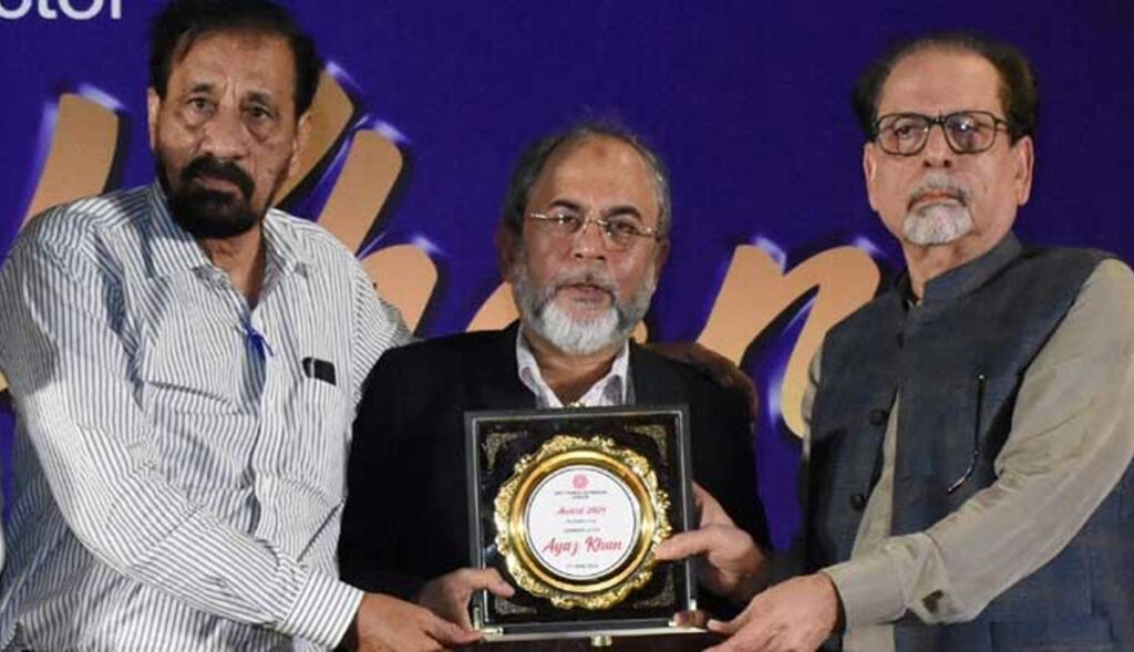 "Muhammad Ahmed Shah presenting a shield to Ayaaz Khan at Arts Council."